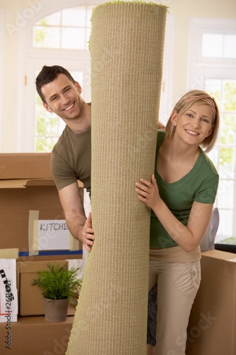 Portrait of couple with rolled up carpet