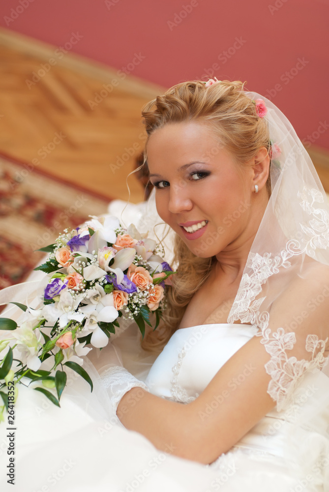 Naklejka premium Wedding. Portrait of bride with bouquet in hands indoors.