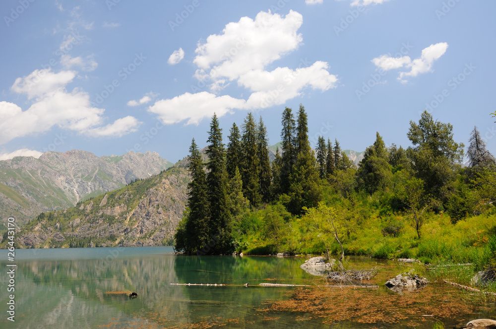 Colorful Sary-Chelek Lake with mountains, sky and clouds