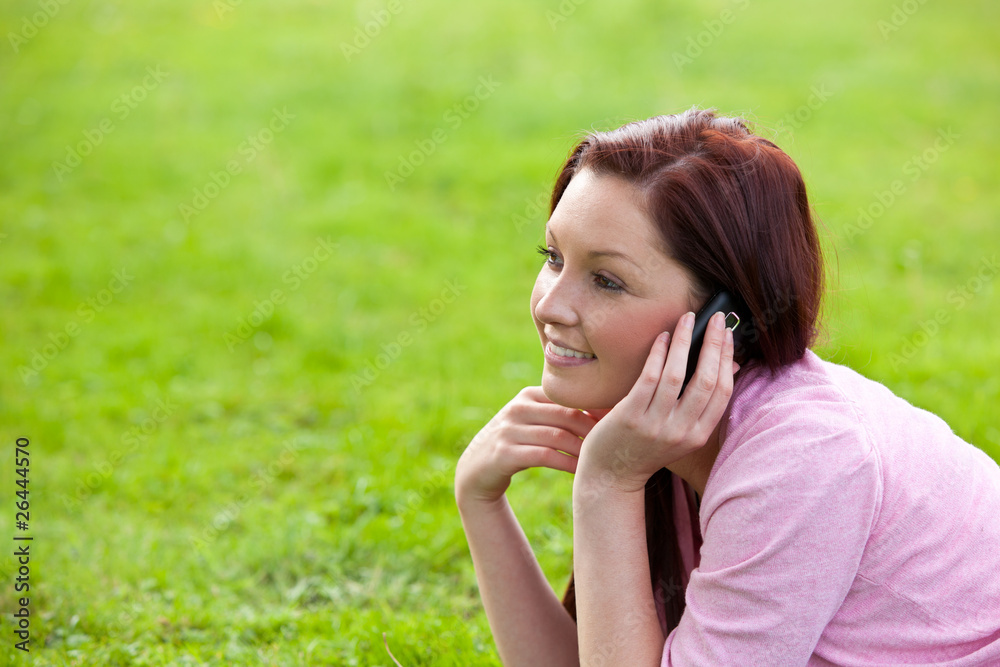 Delighted young woman on phone sitting on the grass Delighted young woman on phone sitting on the grass