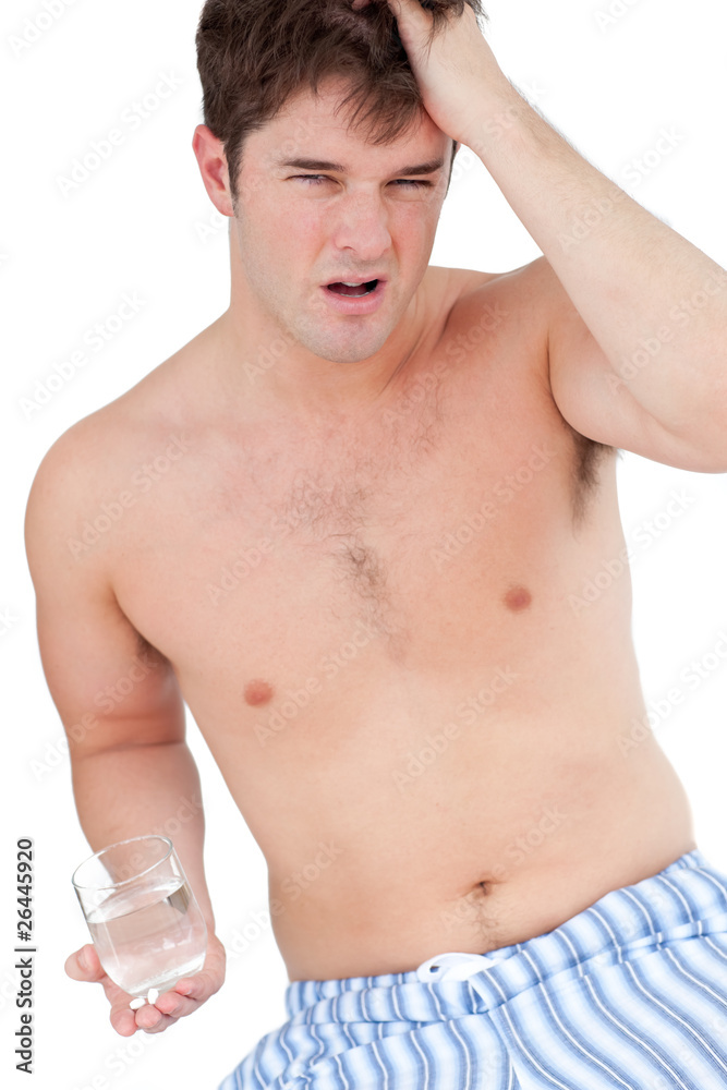 Fototapeta premium exhausted man in pyjamas holding a glass of water looking at the