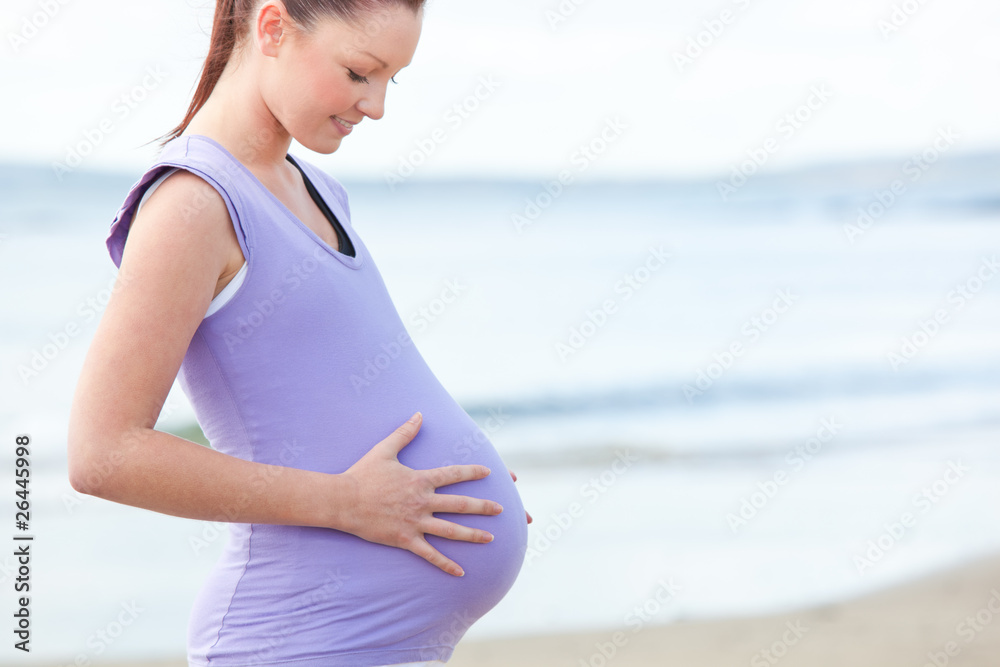 Pregnant smiling woman watching her stomach Pregnant smiling woman watching her stomach
