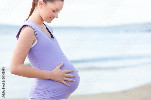 Pregnant smiling woman watching her stomach © WavebreakMediaMicro