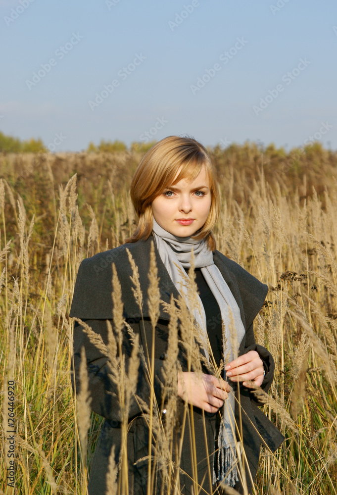 Blonde girl in autumn field with long grass Blonde girl in autumn field with long grass