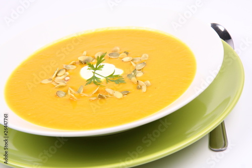 Pumpkin soup decorated with cream, pumpkin seeds and parsley