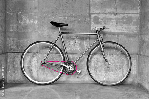 A fixed-gear bicycle in black and white with a pink chain