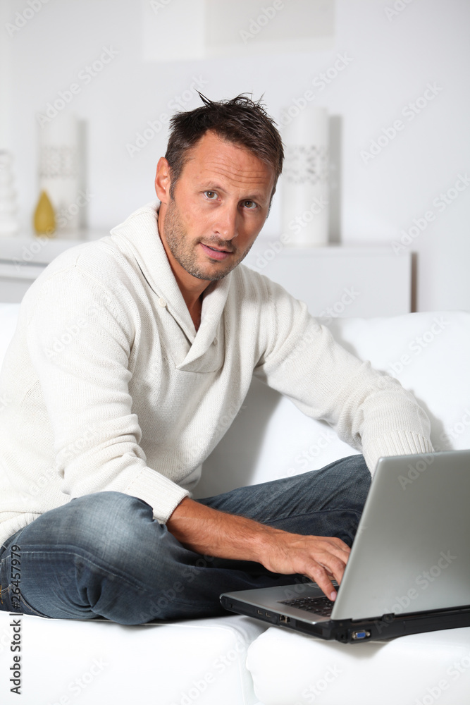 Man with laptop computer sitting in sofa Man with laptop computer sitting in sofa