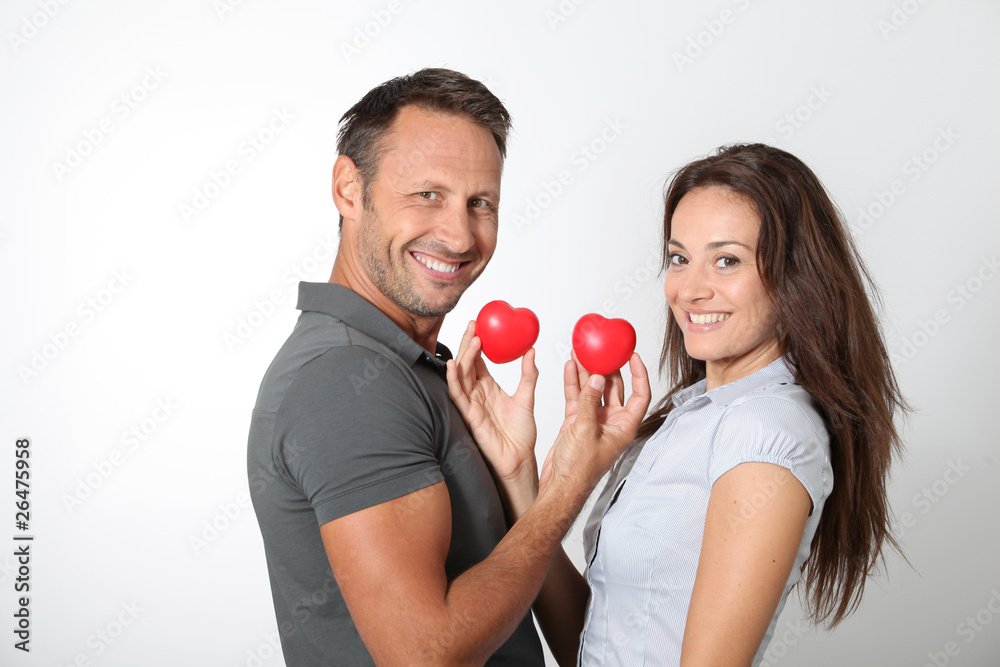 Couple on white background holding red hearts Couple on white background holding red hearts