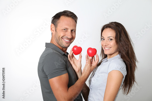 Couple on white background holding red hearts