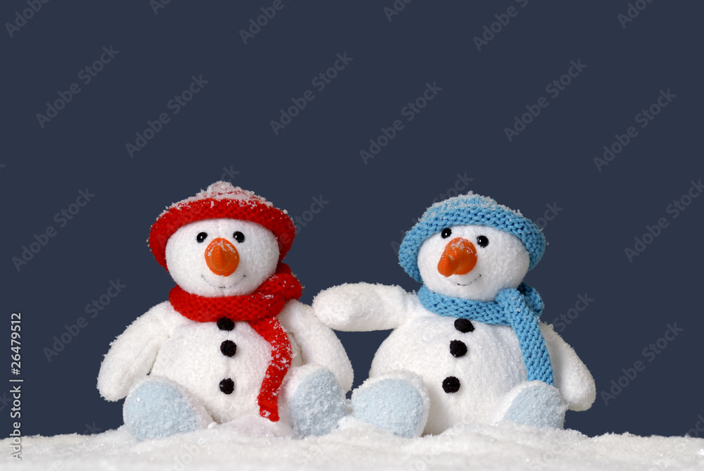 two cute snowmen sitting in the snow two cute snowmen sitting in the snow