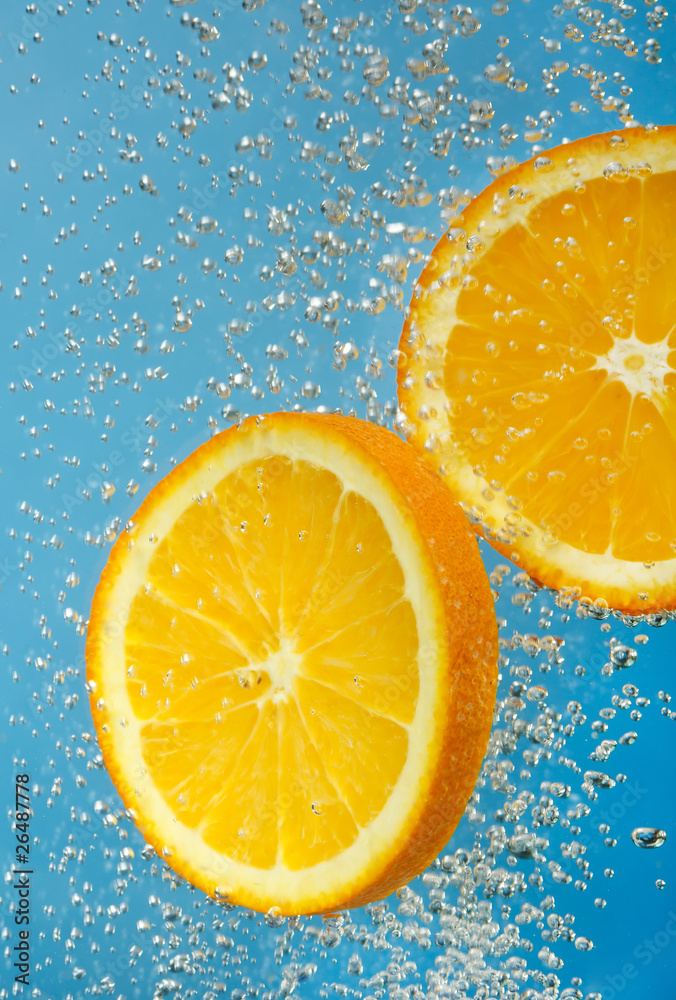 Fresh orange dropped into water Fresh orange dropped into water