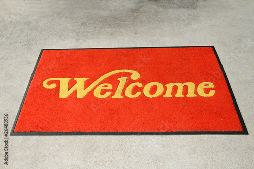 A Red Welcome Mat With Golden Letterings