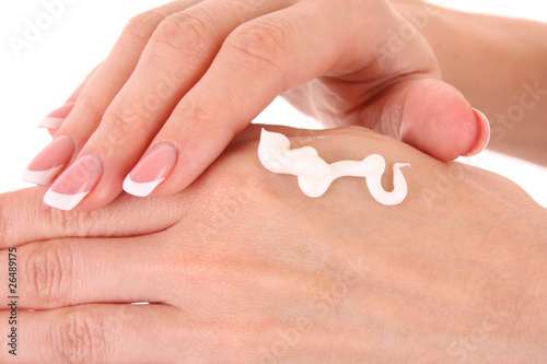 Closeup of beautiful female hands applying hand cream isolated o
