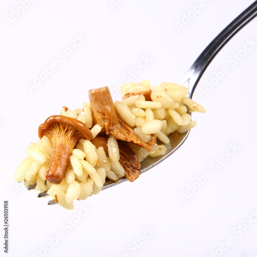 Risotto with mushrooms on a fork on white background