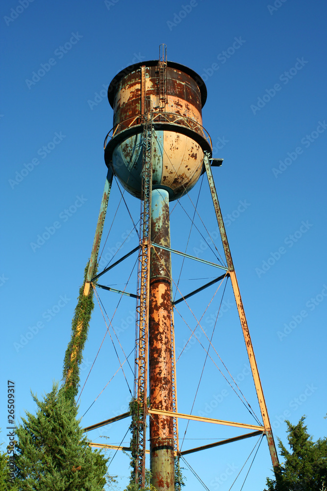 Old rusty watertower against blue sky