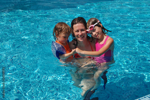 Mother with two kids in swimming pool