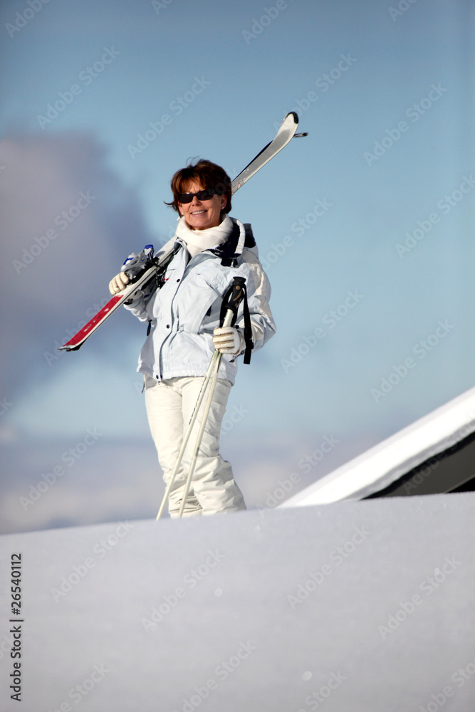 Femme senior avec paire de skis à la neige