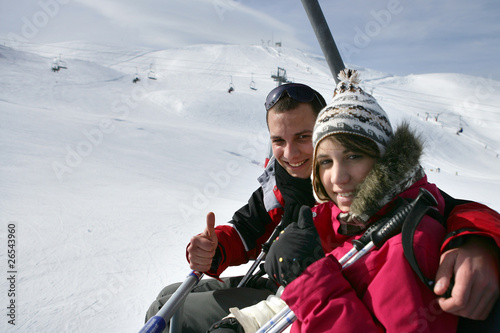 Couple assis sur un télésiège à la neige