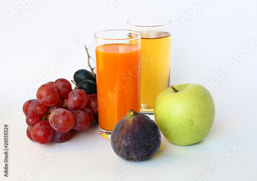 Ripe fruit and two glasses of juice on a white background