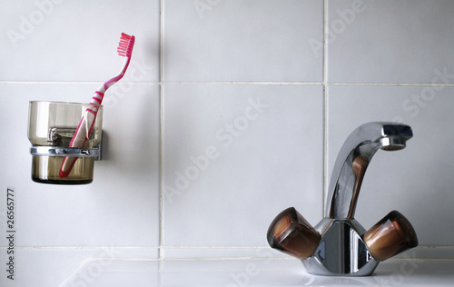 dettaglio di spazzolino da denti e rubinetto photo