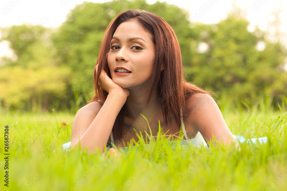 Portrait of young woman lying on grass Portrait of young woman lying on grass