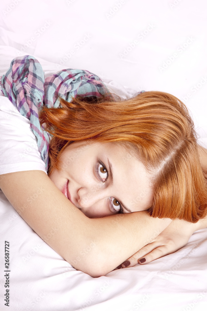 Fototapeta premium Pretty red-haired sleeping woman in white and scarf lying in the