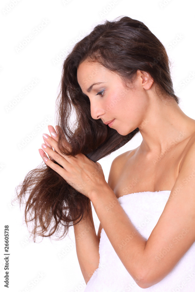 Fototapeta premium Portrait of smiling young beautiful woman holding long brown hai