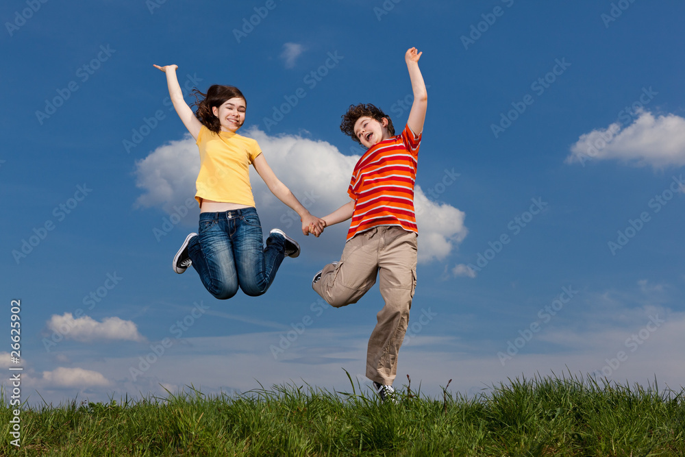 Girl and boy jumping, running against blue sky Girl and boy jumping, running against blue sky