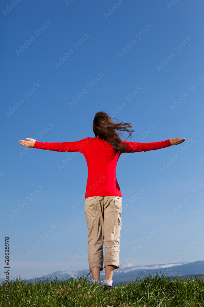 Hope - girl holding arms up against blue sky Hope - girl holding arms up against blue sky