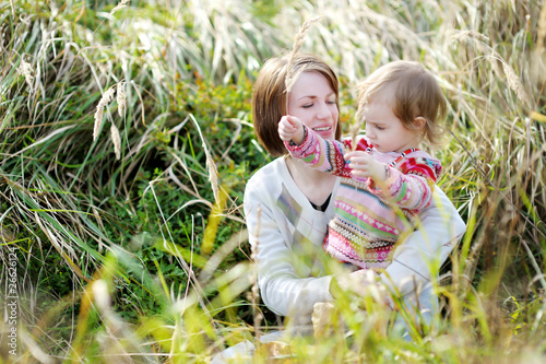 Young mother and her toddler girl in autumn