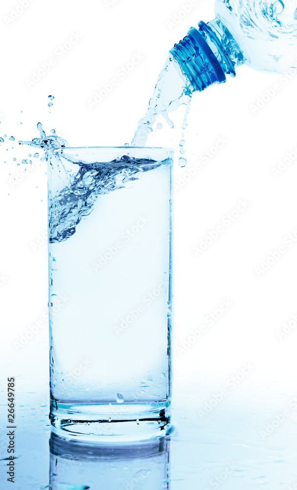 Water is poured from a bottle in a glass Water is poured from a bottle in a glass