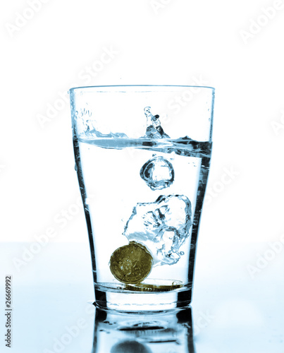 Splash of water and coins in a glass