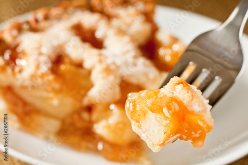 Bite of delicious rustic apple pie on a fork
