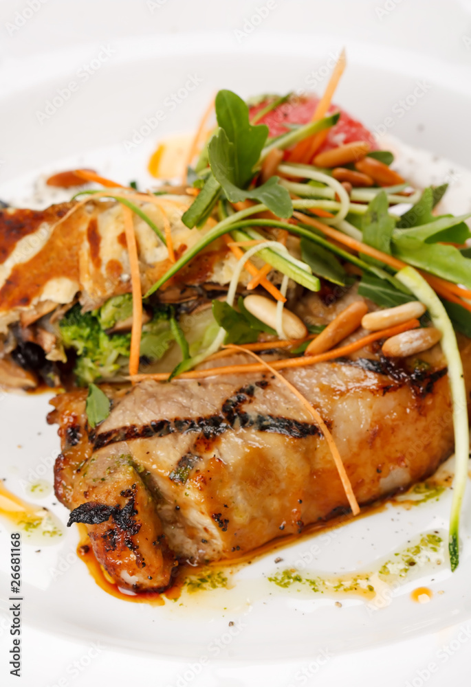 Grilled pork steak with vegetable garnish. Grilled pork steak with vegetable garnish.