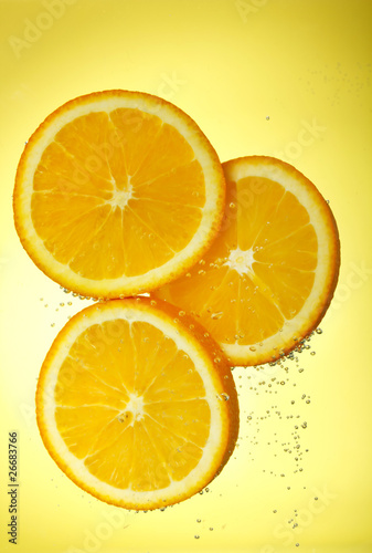 Fresh orange dropped into water
