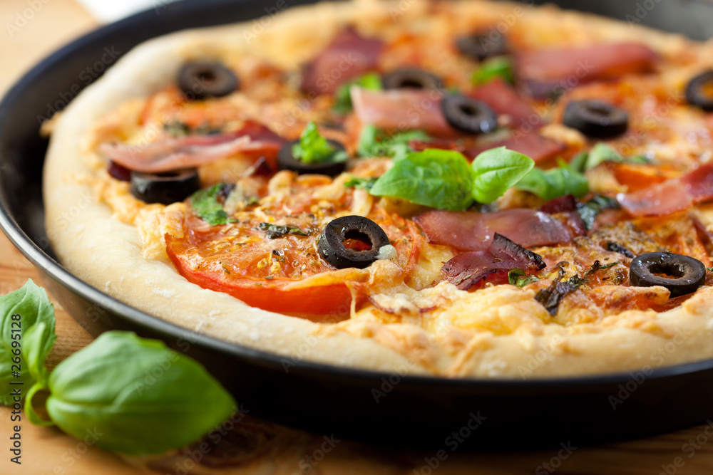 Closeup of pizza with ham and tomatoes Closeup of pizza with ham and tomatoes