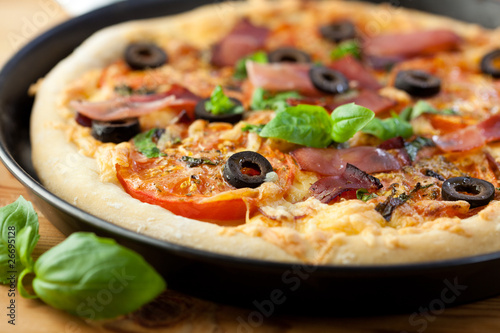 Closeup of pizza with ham and tomatoes