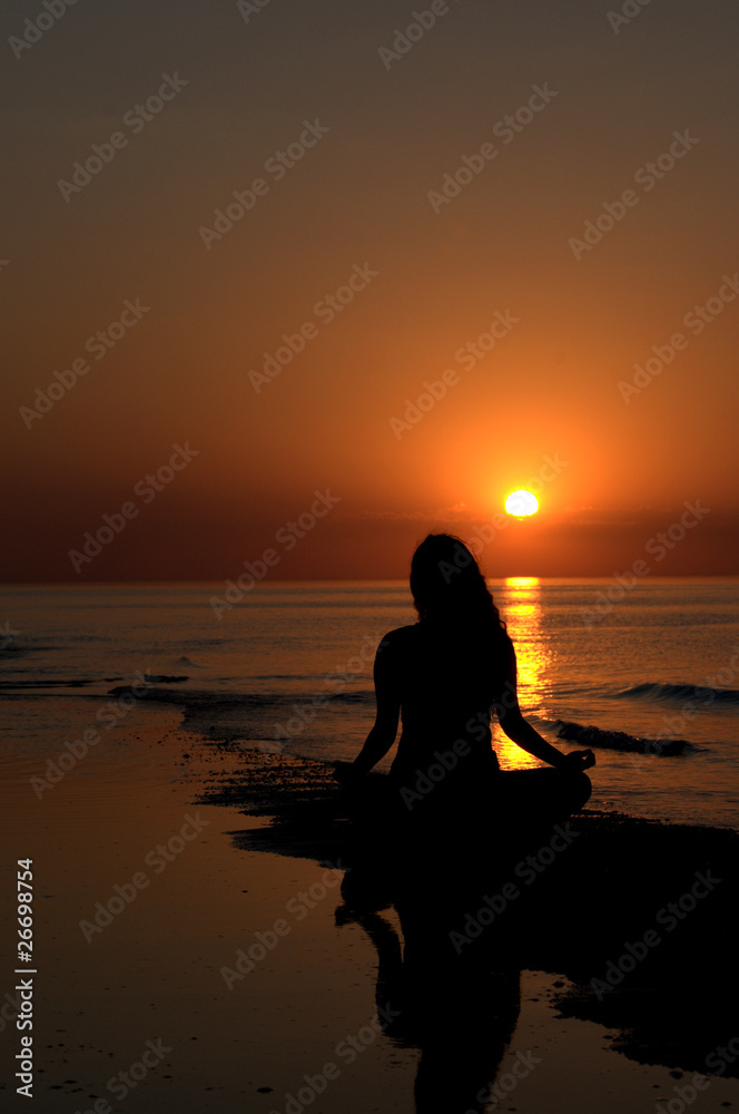 Fototapeta premium Woman meditating at the sunset