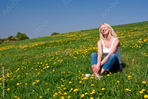 Photos young woman exercising yoga and relaxing on the spring meadow with blooming dand