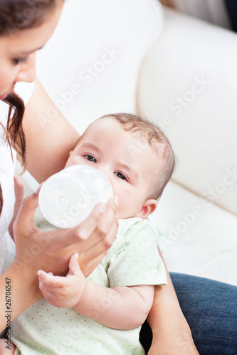 Lovely mother giving milk to her baby on sofa © WavebreakMediaMicro
