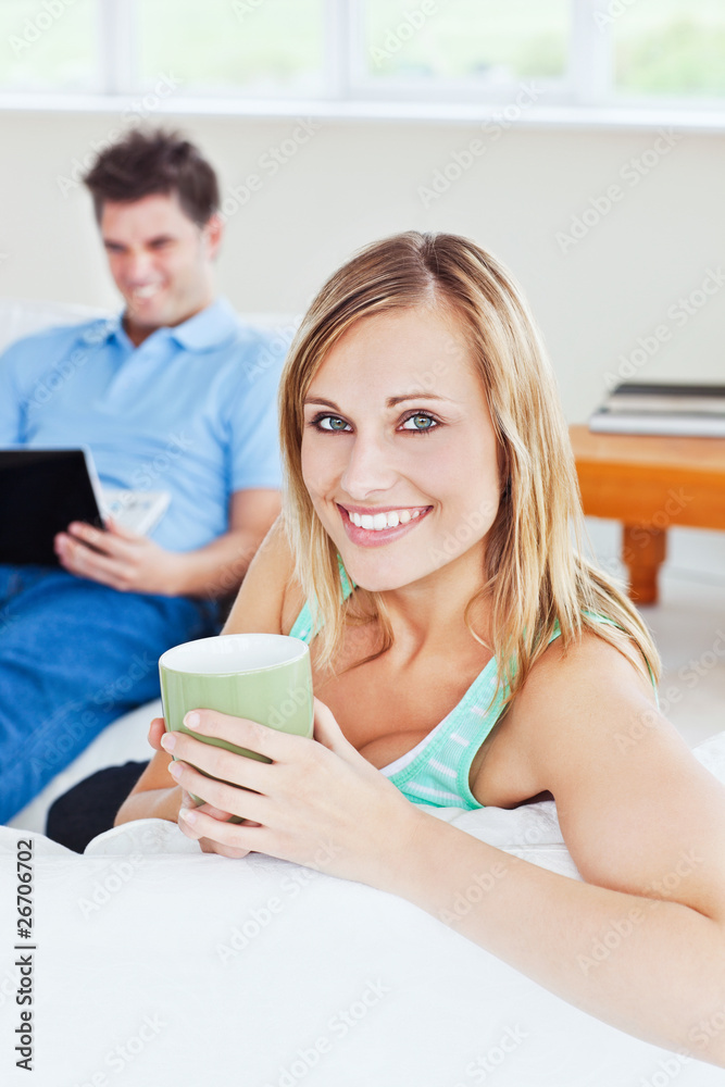 Beautiful woman with coffee while boyfriend using laptop Beautiful woman with coffee while boyfriend using laptop