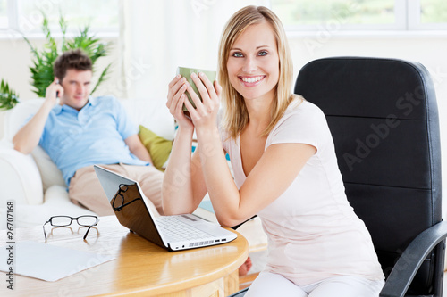 Cheerful woman with coffee and her boyfriend behind