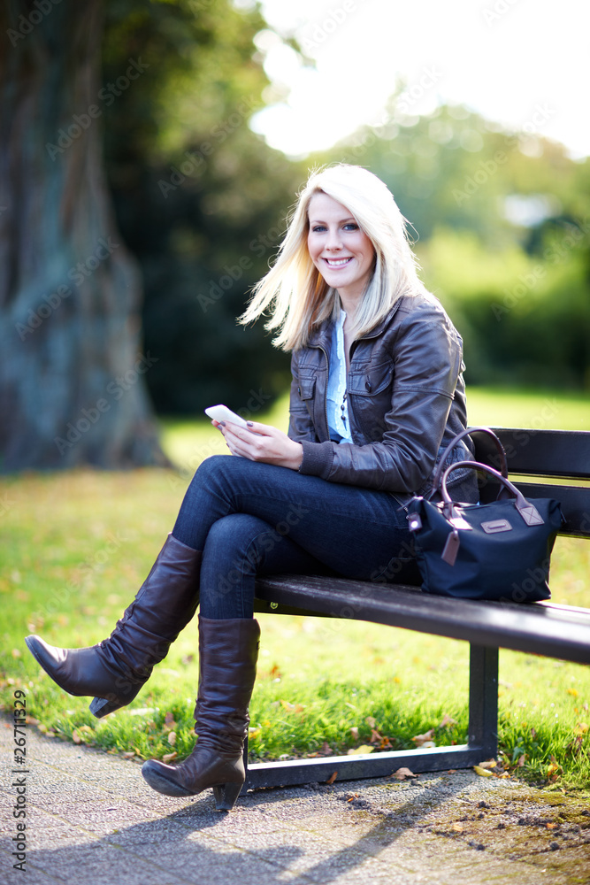 Junge Frau mit Smartphone schreibt SMS Junge Frau mit Smartphone schreibt SMS