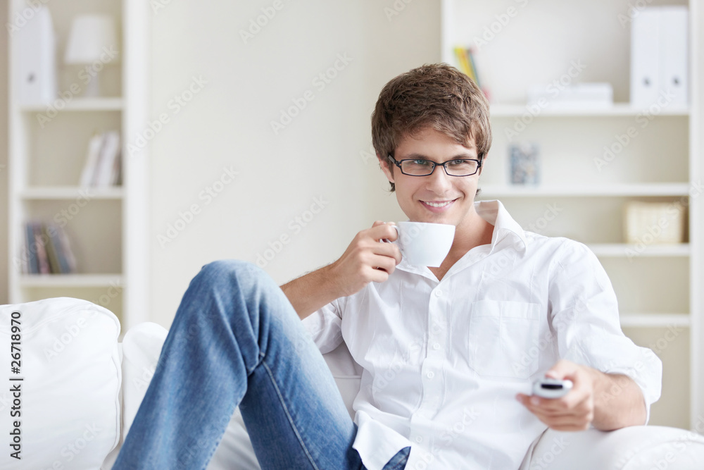 Man drinking coffee on the couch when switching channels