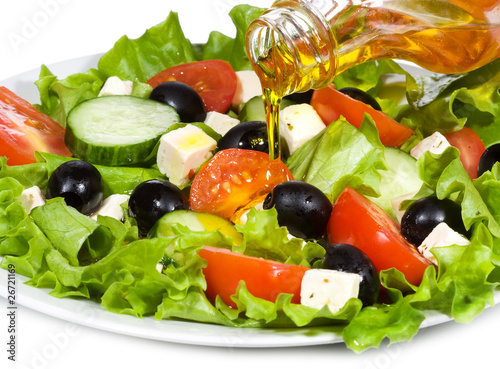 vegetable salad with olive oil pouring from a bottle
