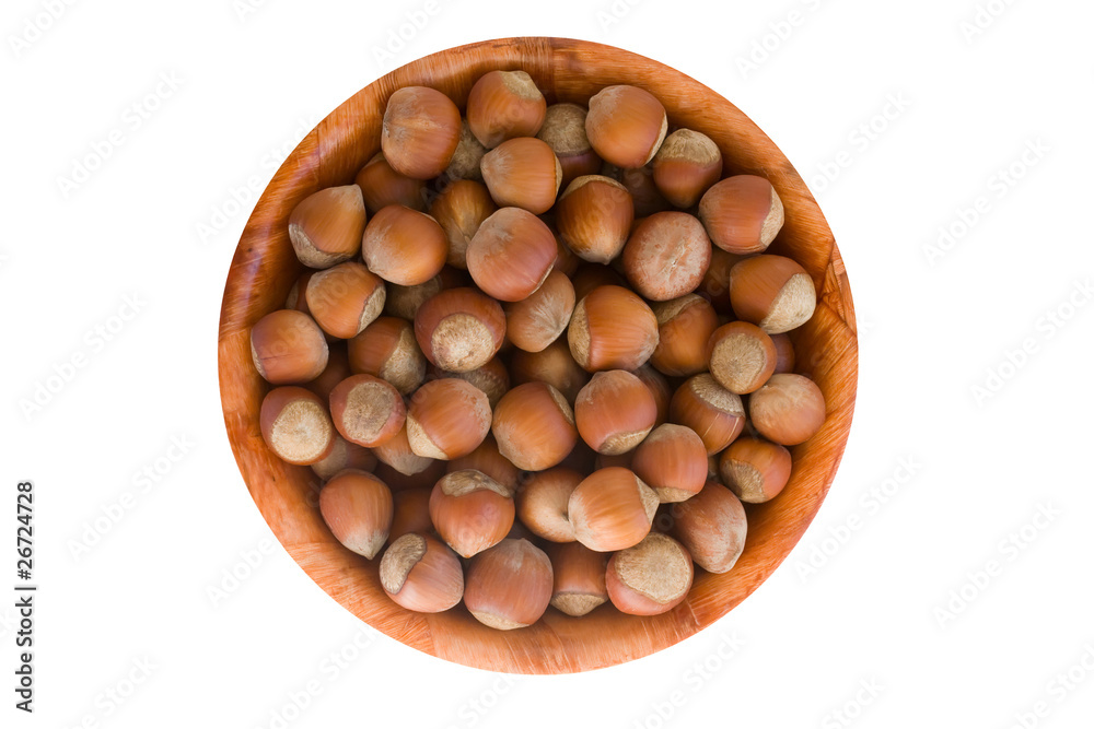 Hazelnut in round wooden plate. isolated on white Hazelnut in round wooden plate. isolated on white
