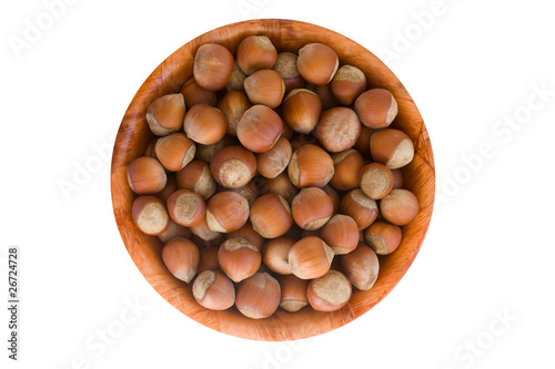 Hazelnut in round wooden plate. isolated on white