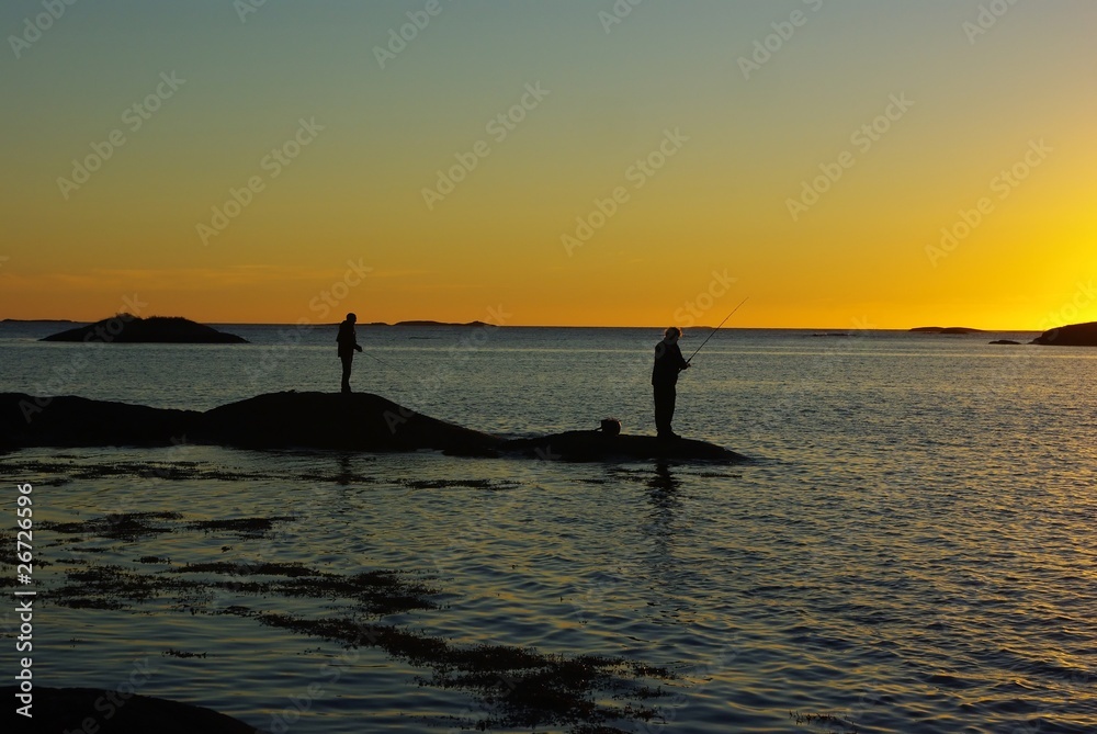 Fisherman silhouettes against sunset