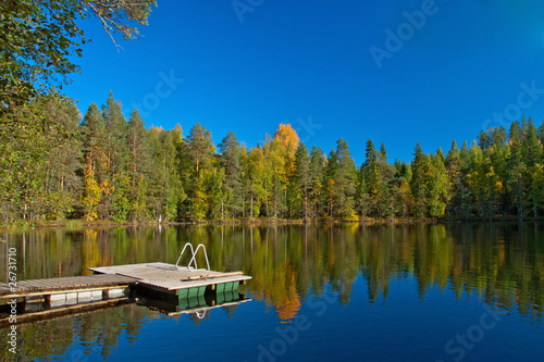 Fototapeta Naklejka Na Ścianę i Meble -  Jetty from sauna to lake with beutiful colors on autumn and refl