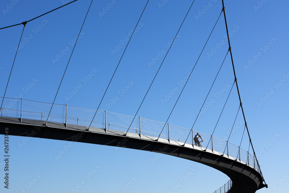 Naklejka premium cyclist crossing a bridge